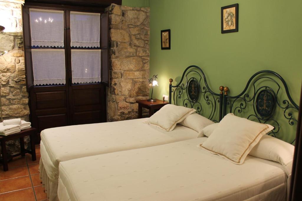 two beds in a bedroom with green walls at Rodiles Rural Apartamentos in Selorio