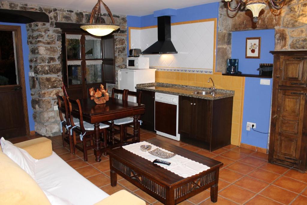 a kitchen with a couch and a table in a room at Rodiles Rural Apartamentos in Selorio
