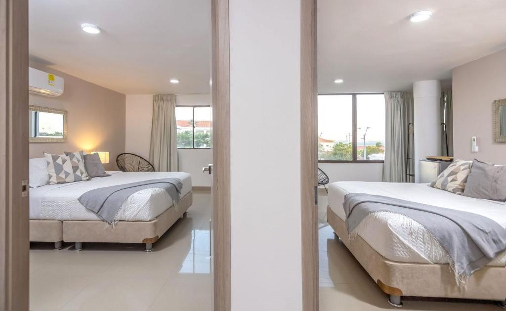 a bedroom with two beds and a large window at Bahari Cartagena Suites in Cartagena de Indias
