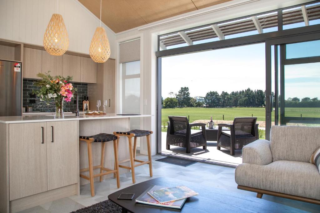 eine Küche und ein Wohnzimmer mit einem Sofa und einem Tisch in der Unterkunft White Rock Accommodation in Martinborough 