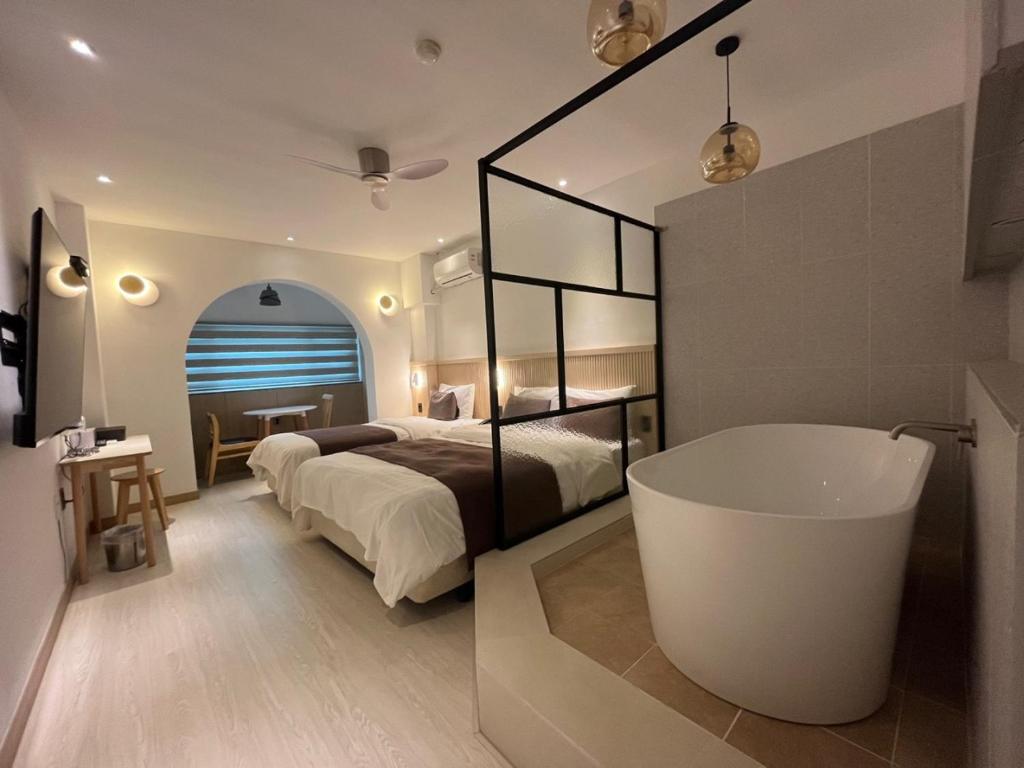 una camera con letto e vasca da bagno di Oceanside Tourist Hotel a Incheon