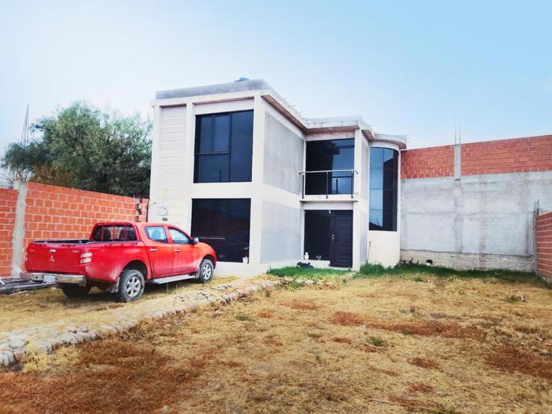 un camión rojo estacionado frente a una casa en Rinconcito familiar, en Tarija