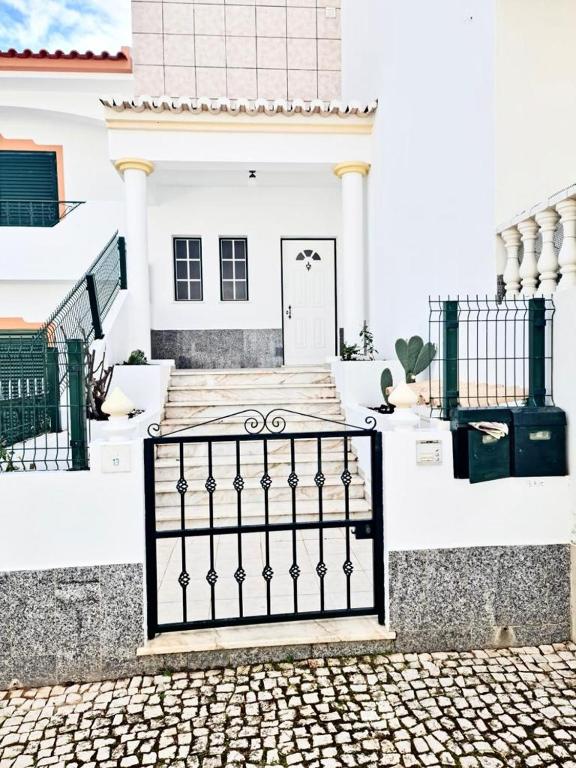 a black gate in front of a white house at Portimão Paradise - Spacious Family Villa in Portimão