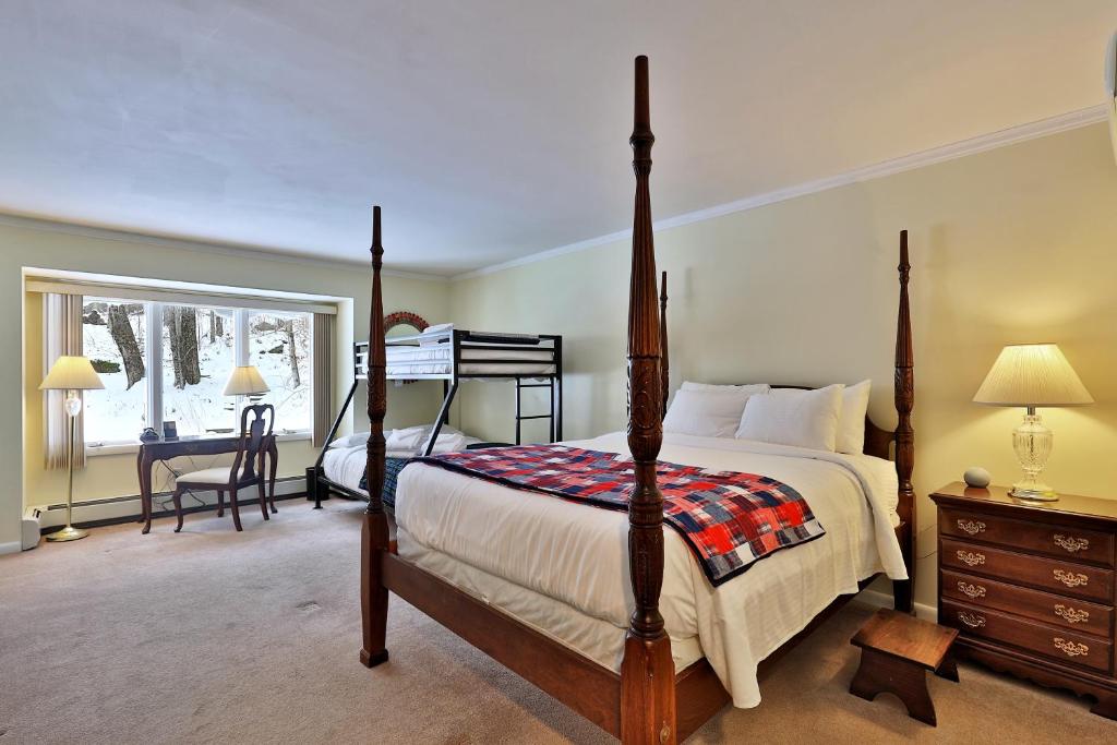 een slaapkamer met een hemelbed en een bureau bij The Birch Ridge- Family Room #11 - Queen Bunkbed Suite in Killington, Vermont home in Killington