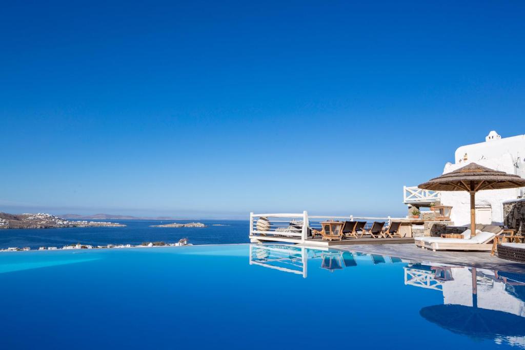 a large swimming pool with a view of the ocean at Vencia Boutique Hotel in Mýkonos City