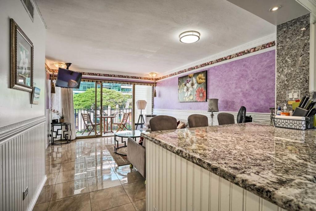 a kitchen and living room with purple walls and a bar at Royal Aloha Wakiki Sweet Home in Honolulu