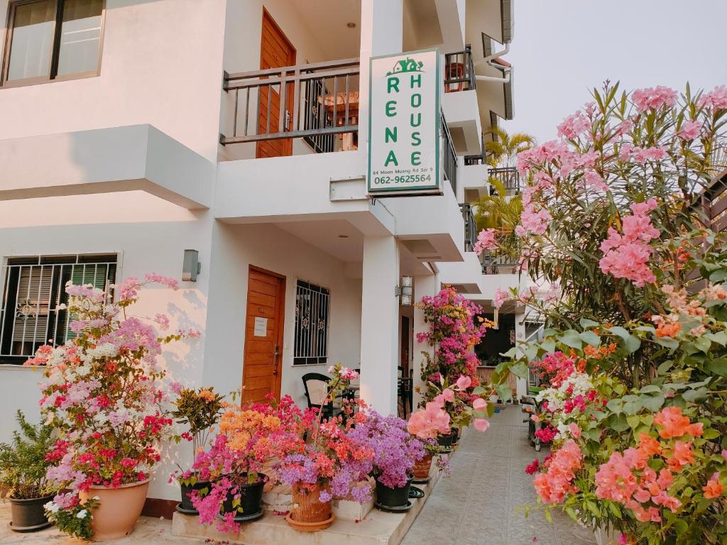 um ramo de flores em vasos em frente a um edifício em Rena House Chiang Mai em Chiang Mai