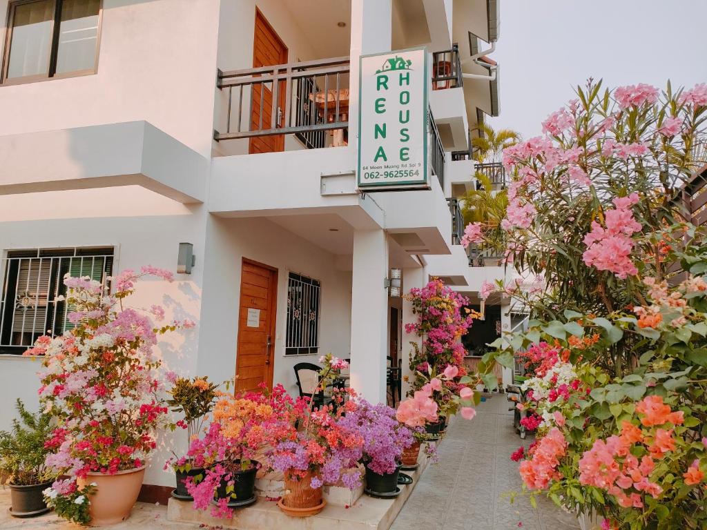 a bunch of flowers in pots in front of a building at Rena House Chiang Mai in Chiang Mai