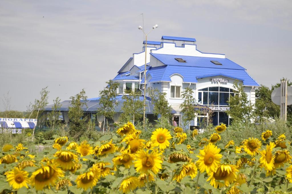 
a blue and yellow house with a blue sky at Hotel Vivat Provincia in Takhtaulove
