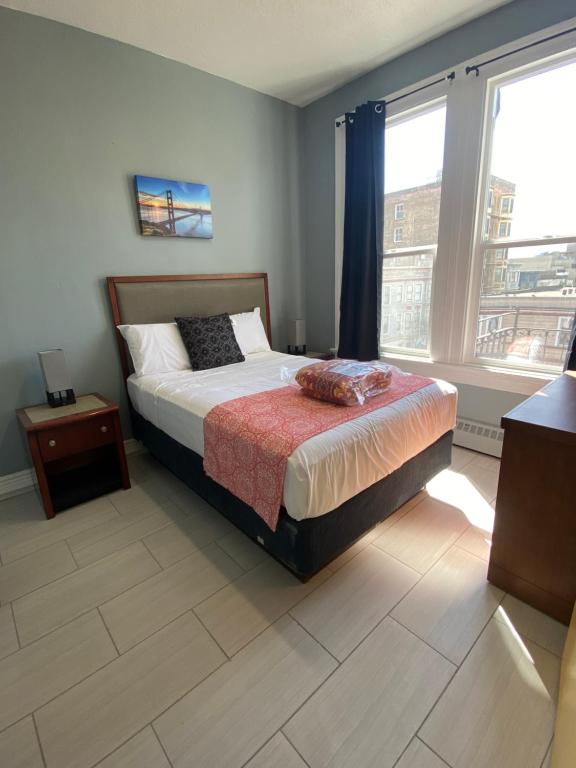 a bedroom with a bed and a large window at SUNSET HOTEL - Downtown San Francisco in San Francisco