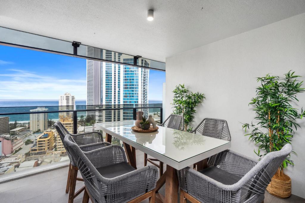 a dining room with a table and chairs and a large window at Circle on Cavill Contemporary Luxury and Spacious Three Bedroom Apartment in Gold Coast