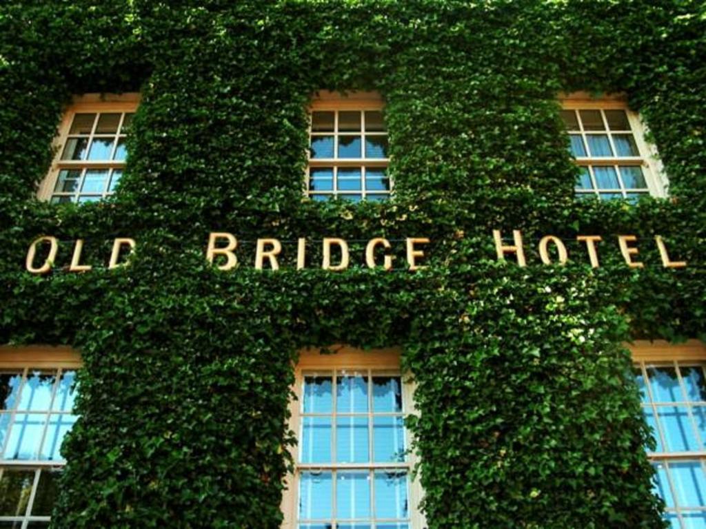 亨廷登的住宿－奧德布里奇酒店，一座常春藤覆盖的建筑,上面写着旧桥酒店
