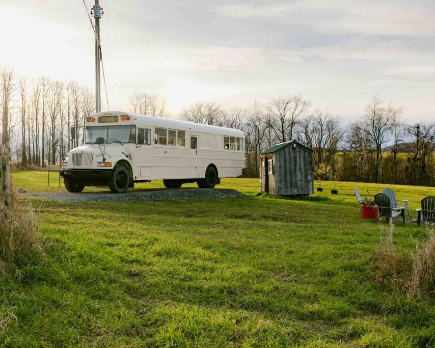 un autobús blanco está estacionado en un campo en Serene Bus Getaway Among Rolling Farm Land en Granville
