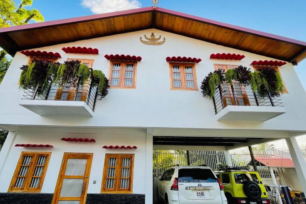 a white house with a car parked in front of it at A Luxury Duplex in Dili City, Timor-Leste in Dili