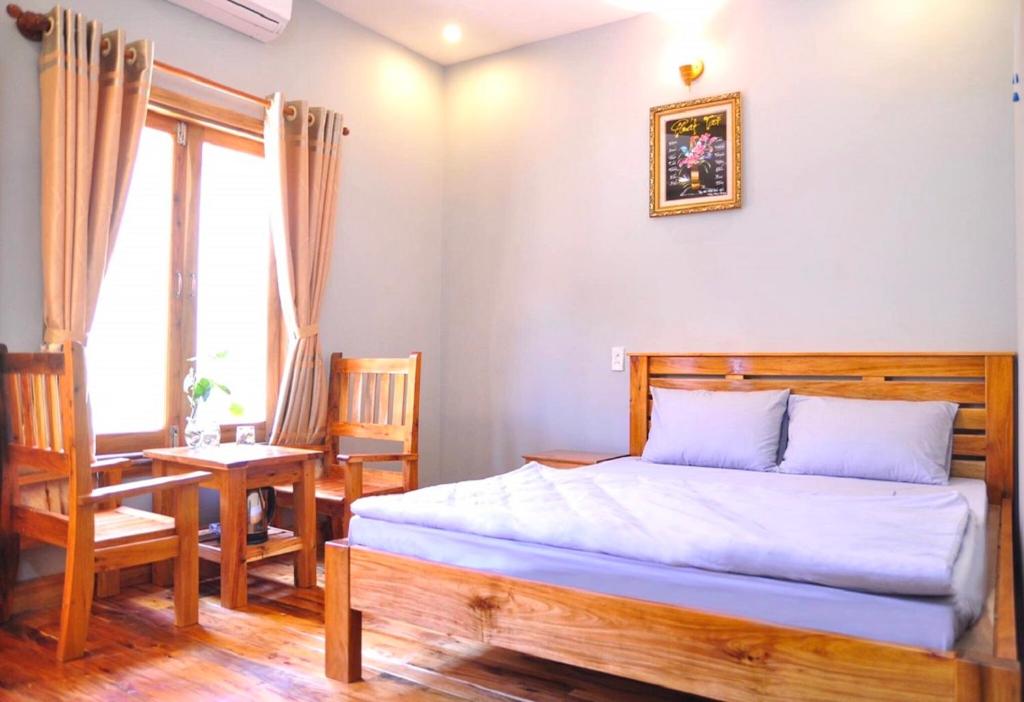 Schlafzimmer mit einem Bett, einem Tisch und Stühlen in der Unterkunft Liên tho Phú Quốc in Phu Quoc