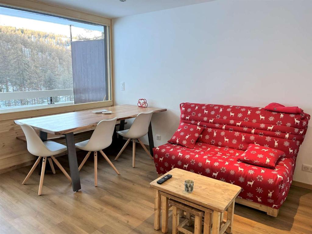 un salon avec un canapé rouge et une table dans l'établissement Charmant T2 cabine, rénové, 6 couchages, à 20m des pistes, parking privé – Vars Les Claux - FR-1-330B-208, à Vars