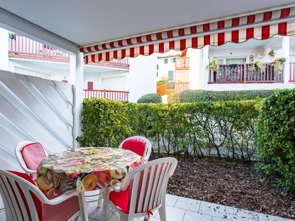 une table et des chaises assises sur une terrasse dans l'établissement Appartement Hendaye, 2 pièces, 4 personnes - FR-1-2-418, à Hendaye