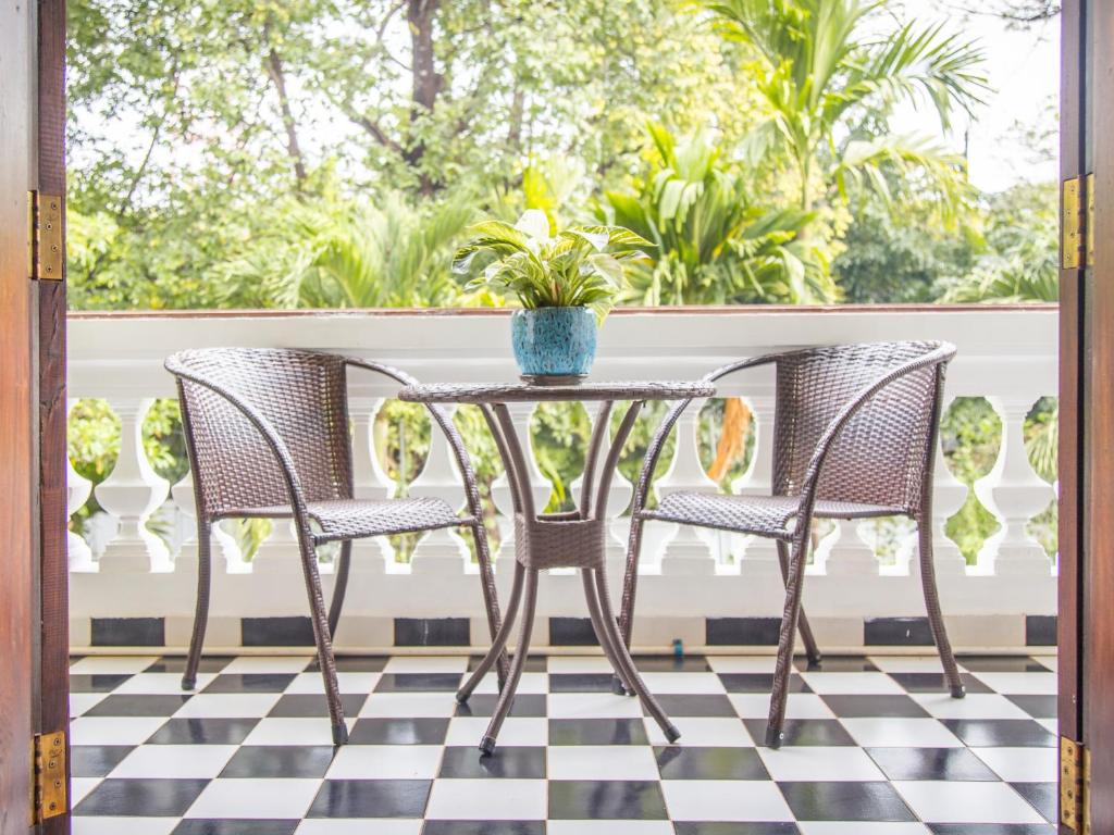 a patio table with two chairs and a potted plant at Chateau d'Angkor La Residence in Siem Reap