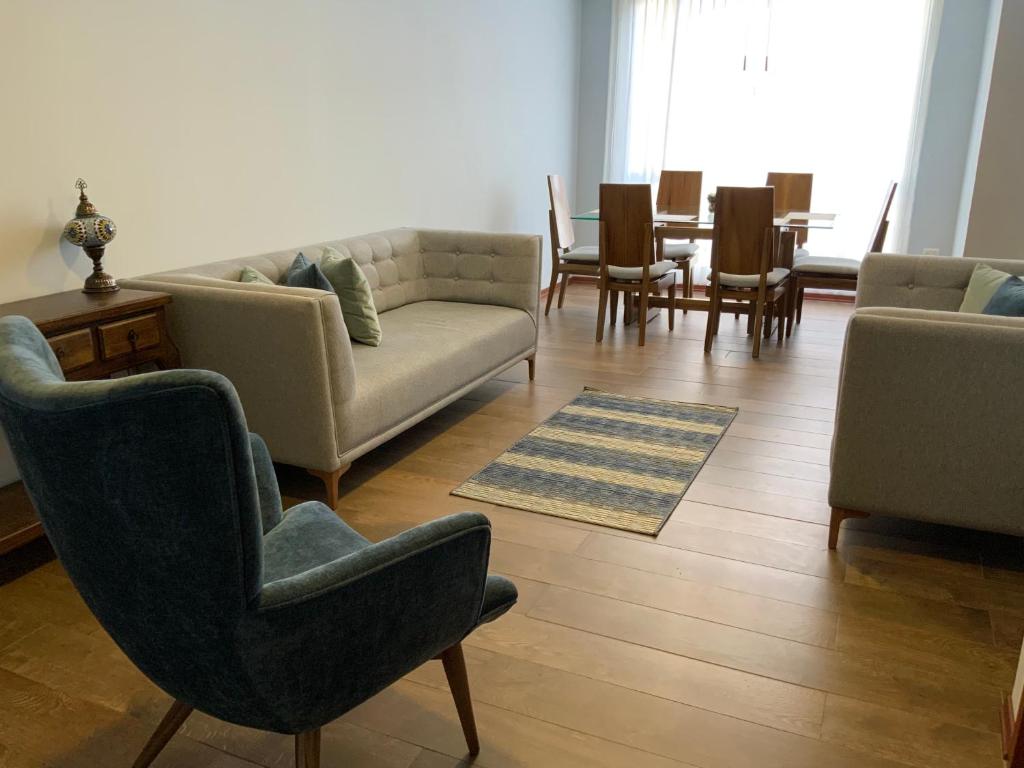 sala de estar con sofás, sillas y mesa en Serenity Inn, en Quito