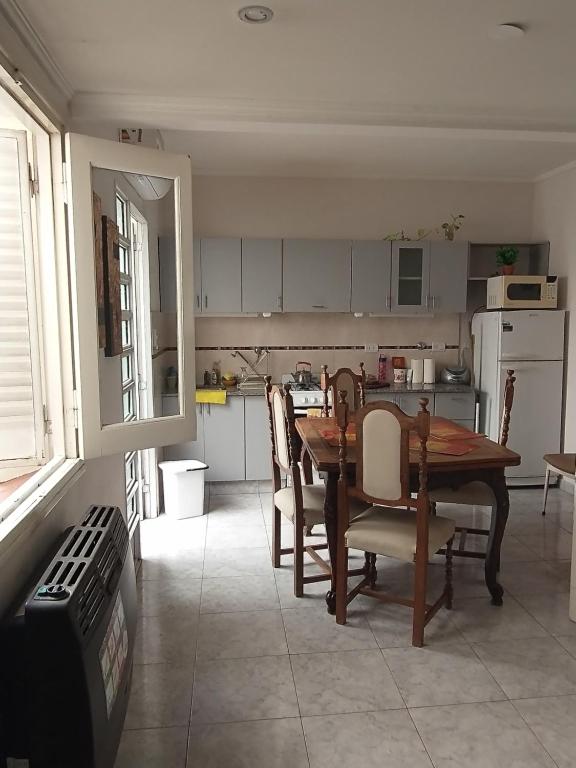 cocina y comedor con mesa y sillas en Casa Mariclaire en Bahía Blanca