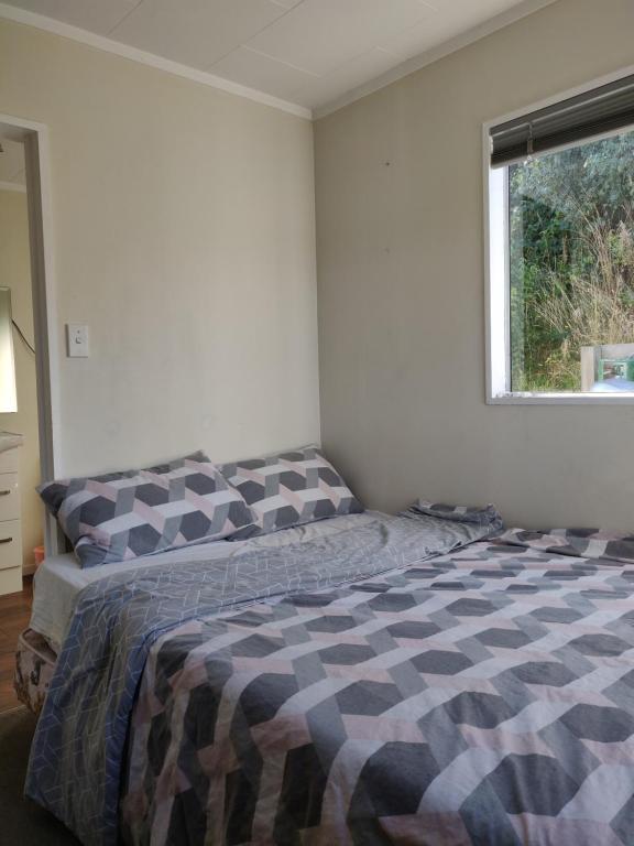 1 dormitorio con 1 cama en una habitación con ventana en wanaka plantation road room, en Wanaka