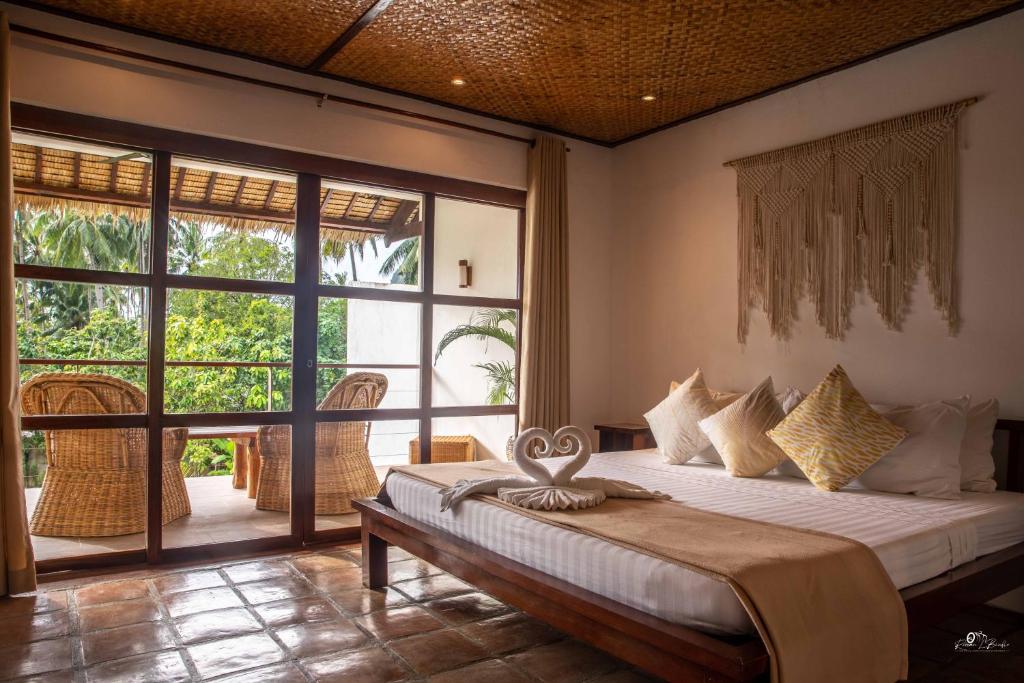 a bedroom with a bed and a large window at El Nido Moringa Resort in El Nido
