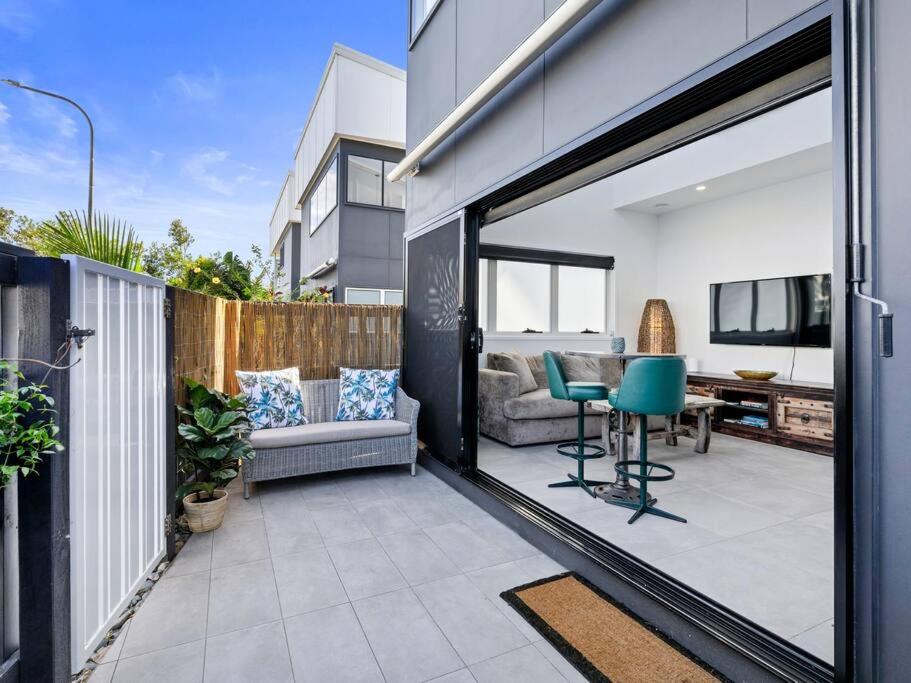 a patio with a couch and a table on a balcony at 1 Bedroom Modern Townhouse in Casuarina in Casuarina