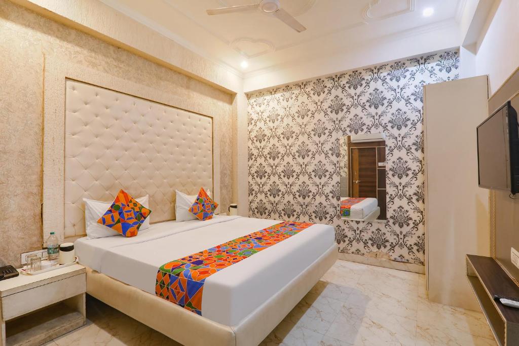 a bedroom with a large white bed and a tv at FabHotel Triveni in Jahāngīrābād