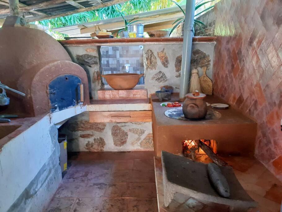 eine Küche mit einem Steinofen und einem Herd in der Unterkunft Casa de Mamá Nico in Barrio Nuevo
