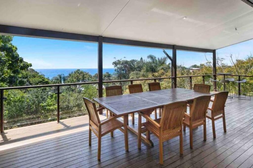 une table à manger et des chaises sur une terrasse avec vue dans l'établissement Treetops on Tramican - Ocean View - sleeps 10, à Point Lookout