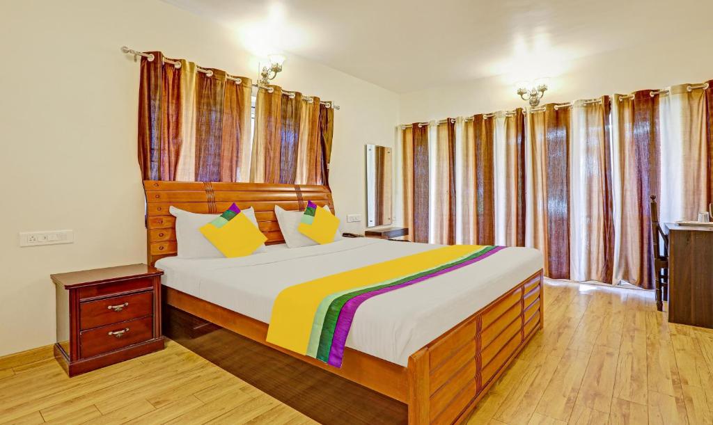 a bedroom with a large bed and some windows at Itsy By Treebo - Twin Falls in Ooty