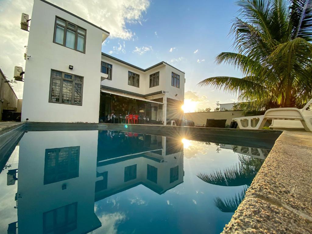 una casa con piscina frente a una casa en Mungur villa, en Flic en Flac