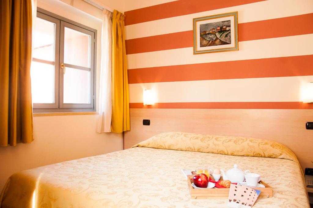 a bedroom with a bed with a tray of fruit on it at Lizard Hotel in Como