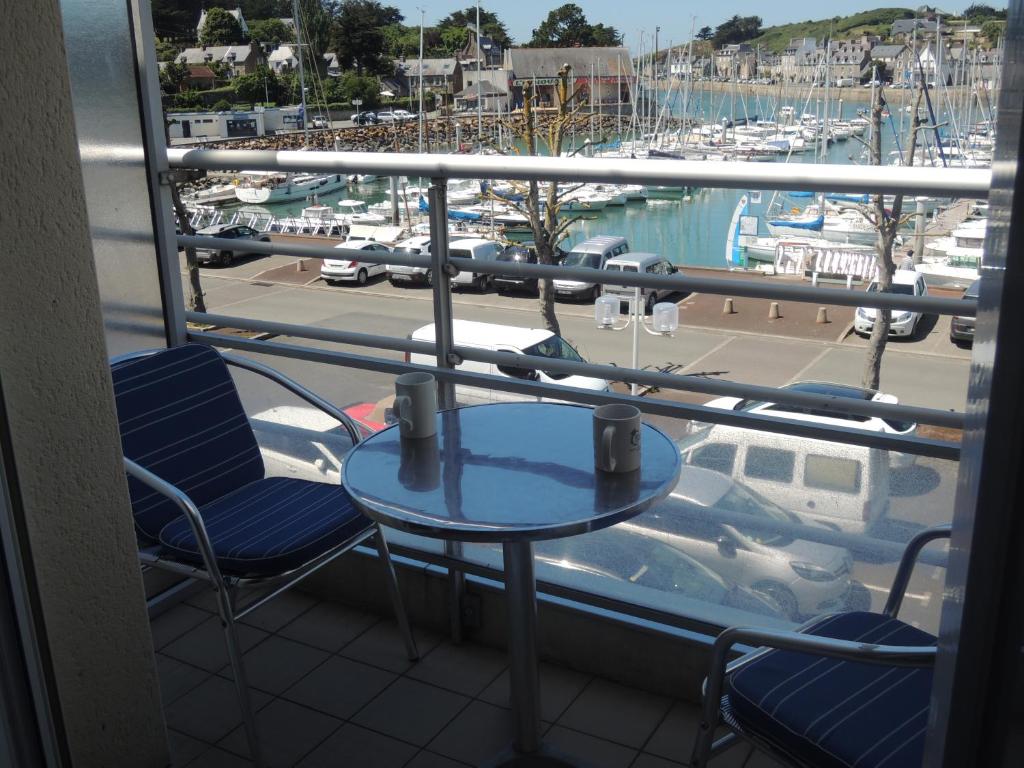 d'un balcon avec une table et des chaises ainsi qu'un port de plaisance. dans l'établissement Joli appartement avec wifi sur le port de Dahouet, à Pléneuf-Val-André