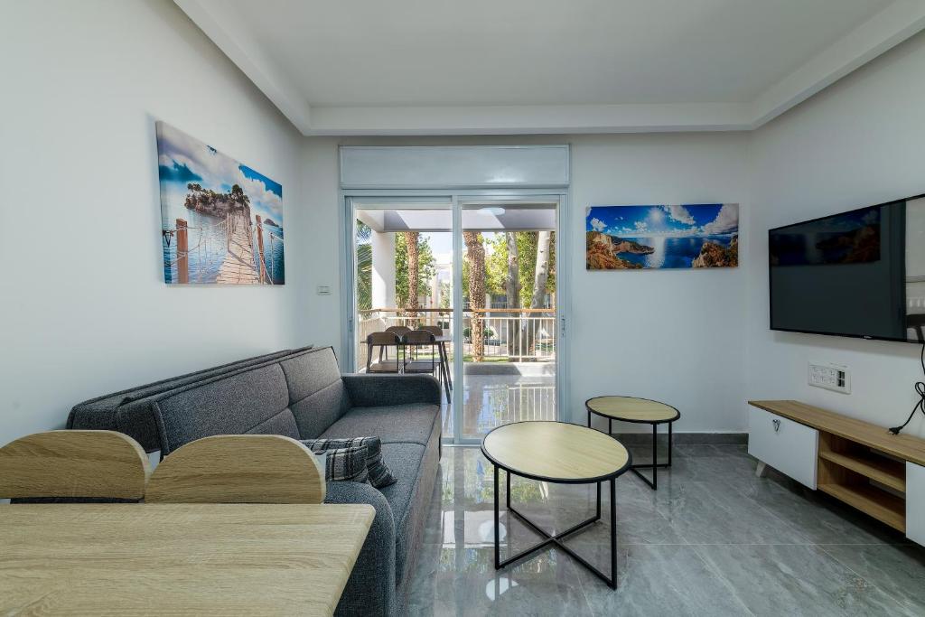 a living room with a couch and a tv at Kings suite at Royal Park Eilat in Eilat
