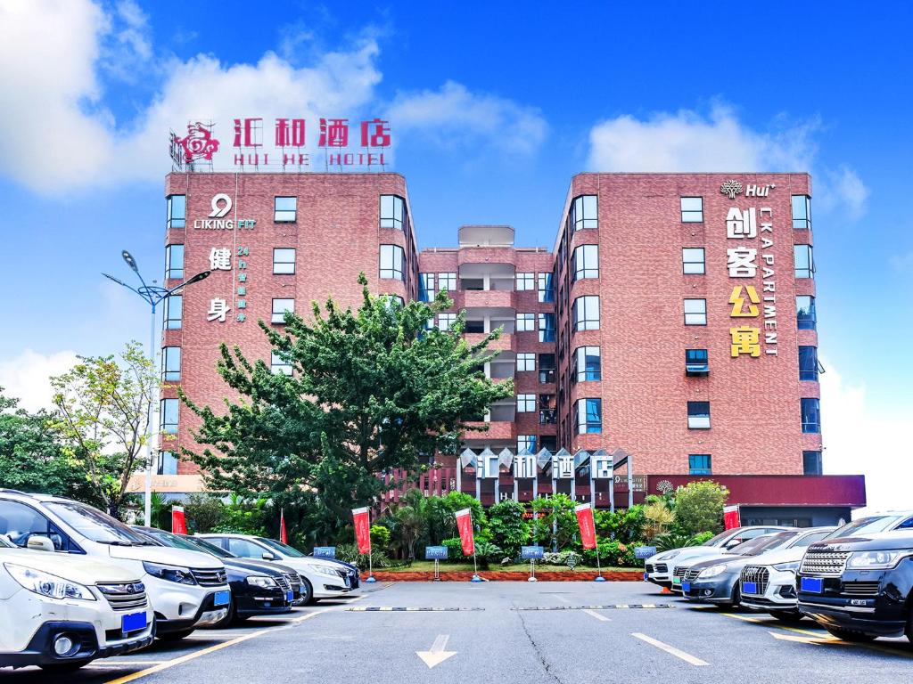 a parking lot with cars parked in front of a building at Guangzhou Huihe Hotel in Guangzhou