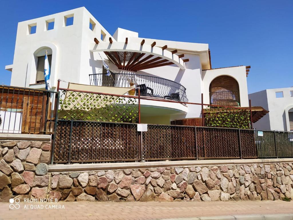 una casa blanca con una valla delante en Apartment Amdar Village, en Eilat