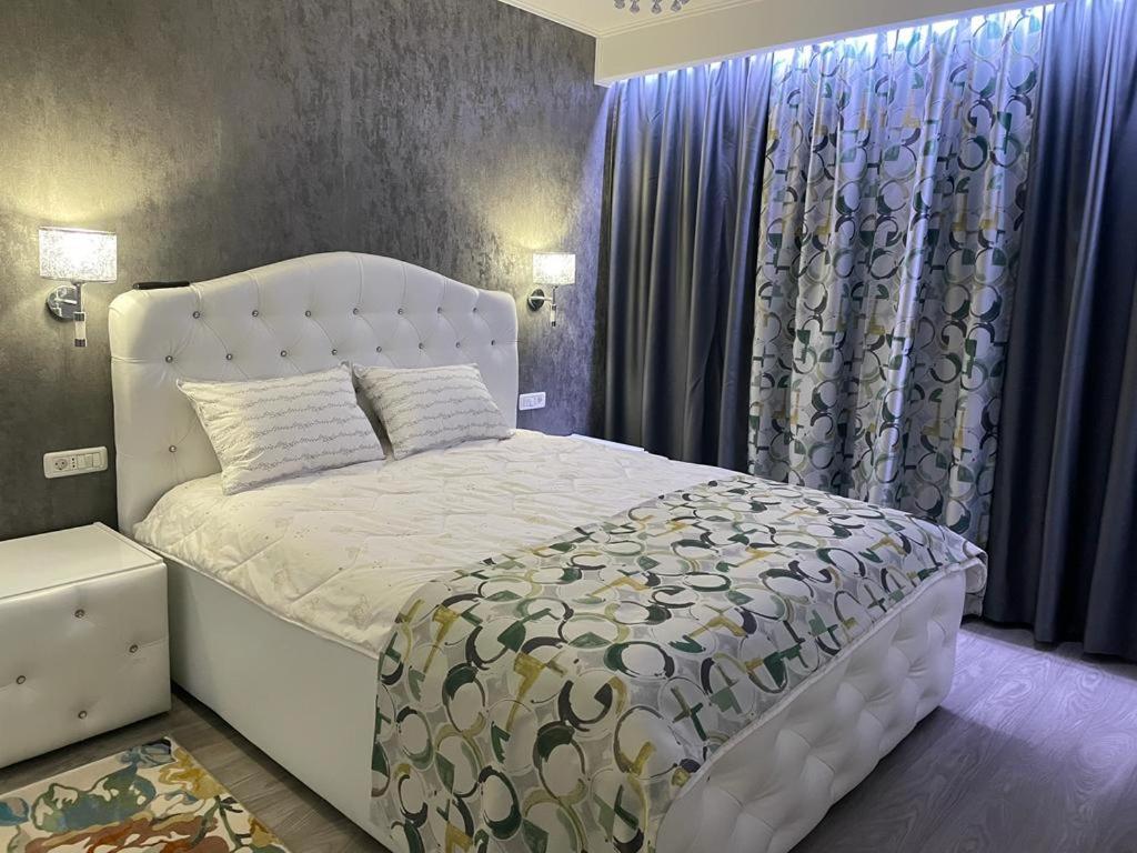 1 dormitorio con cama blanca y cortinas azules en Amira 2, en Târgovişte