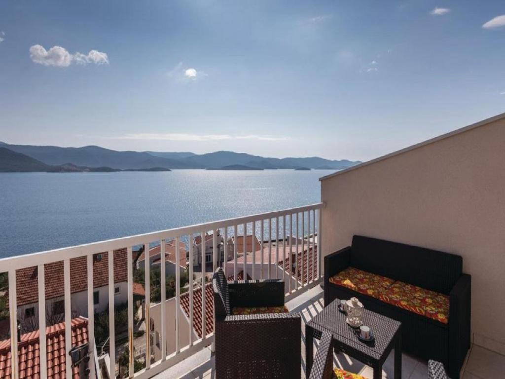 einen Balkon mit Sofa und Blick auf das Wasser in der Unterkunft Apartman Sutalo in Komarna