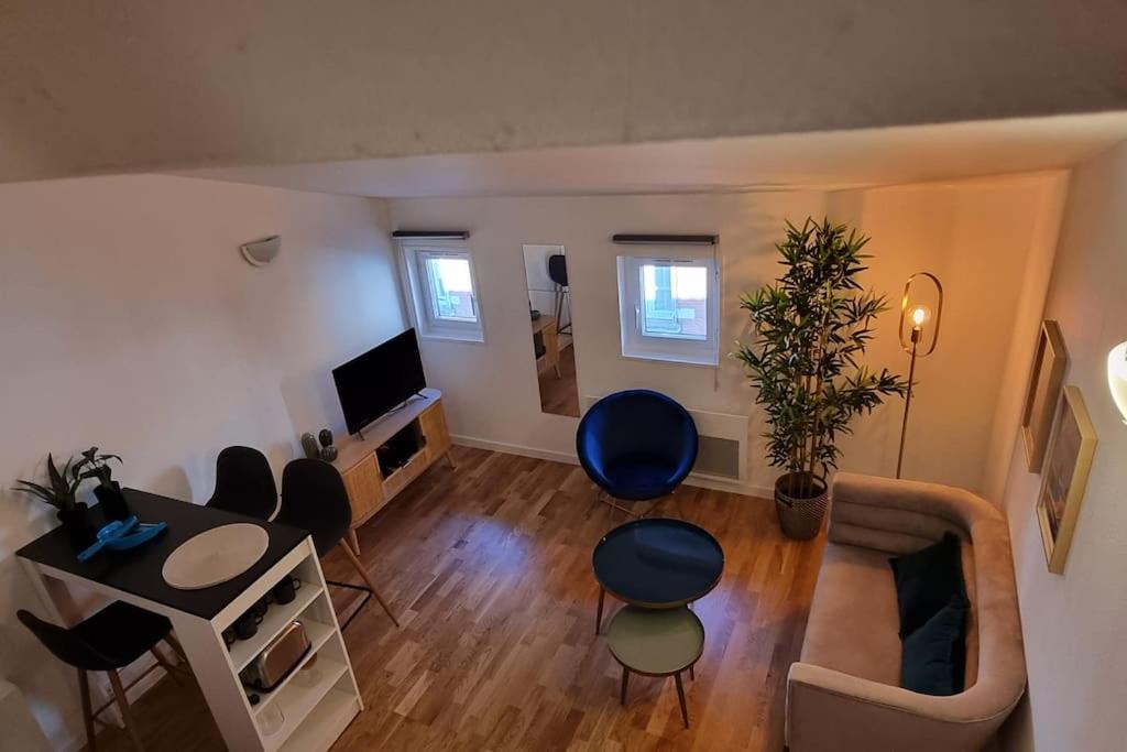uma sala de estar com um sofá, uma mesa e cadeiras em T2 Charmant - Hypercentre - Quai de Garonne - Wifi em Toulouse