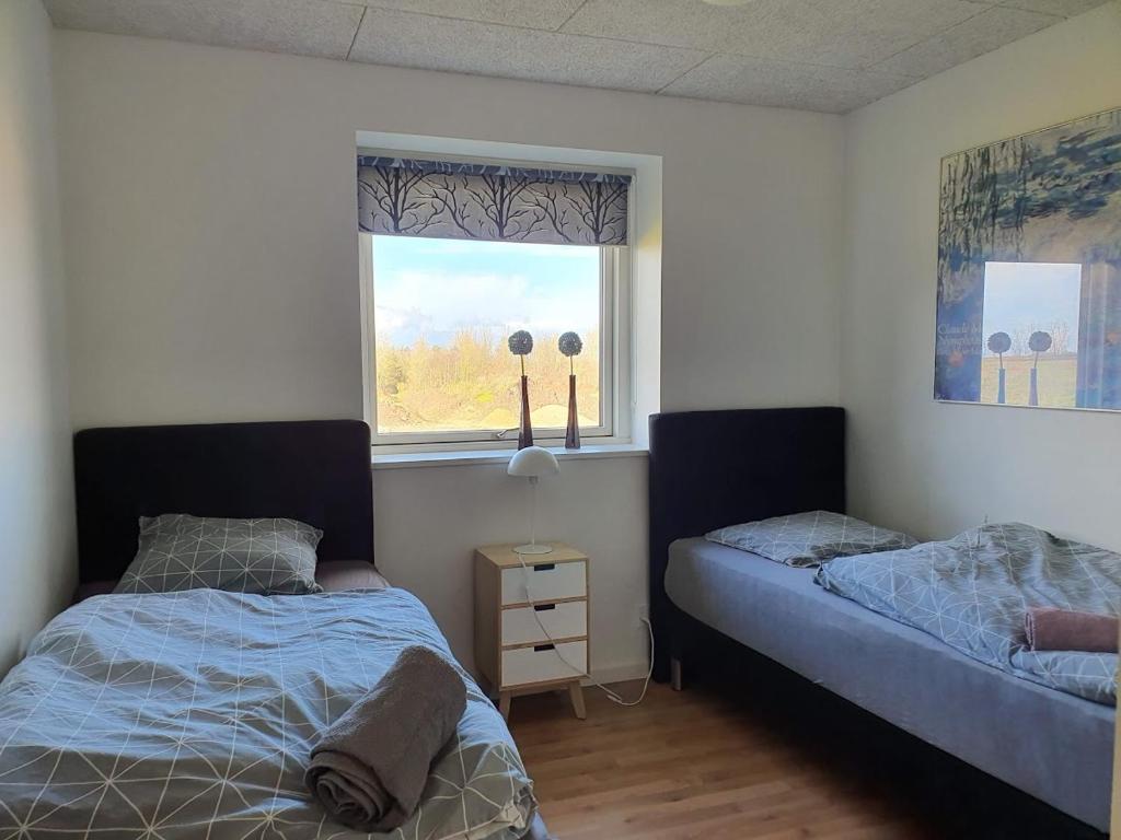 1 dormitorio con 2 camas y ventana en Fælleshuset Kirkebakken, en Otterup