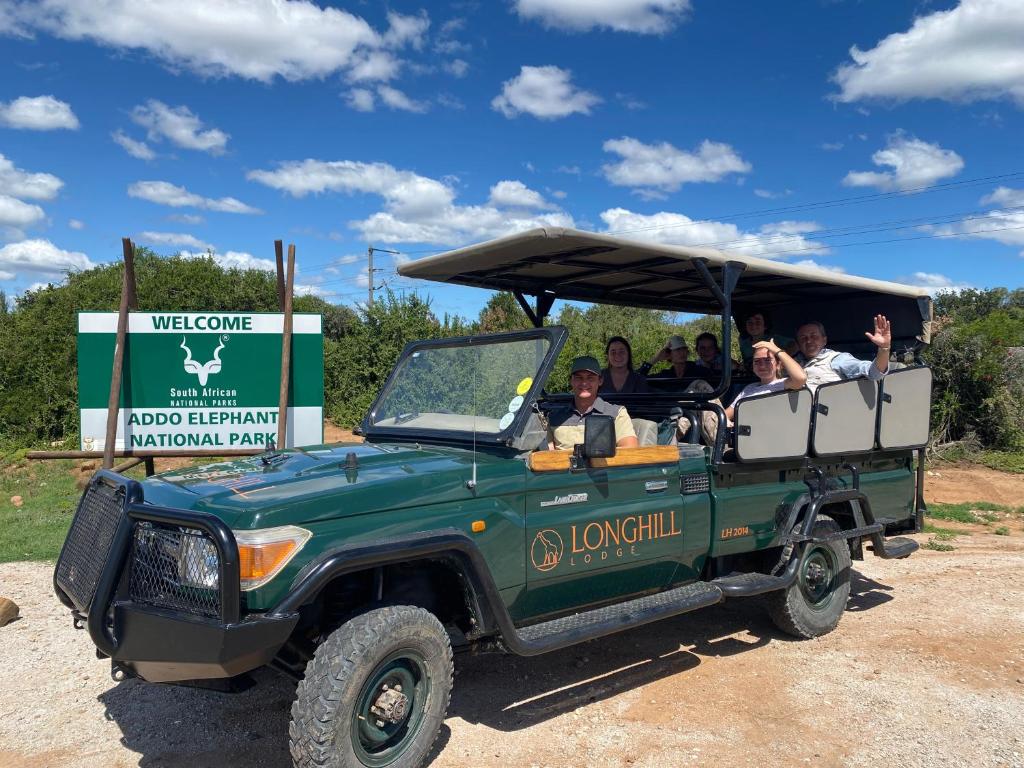 Un groupe de personnes voyageant en jeep verte dans l'établissement Longhill Lodge, à Addo