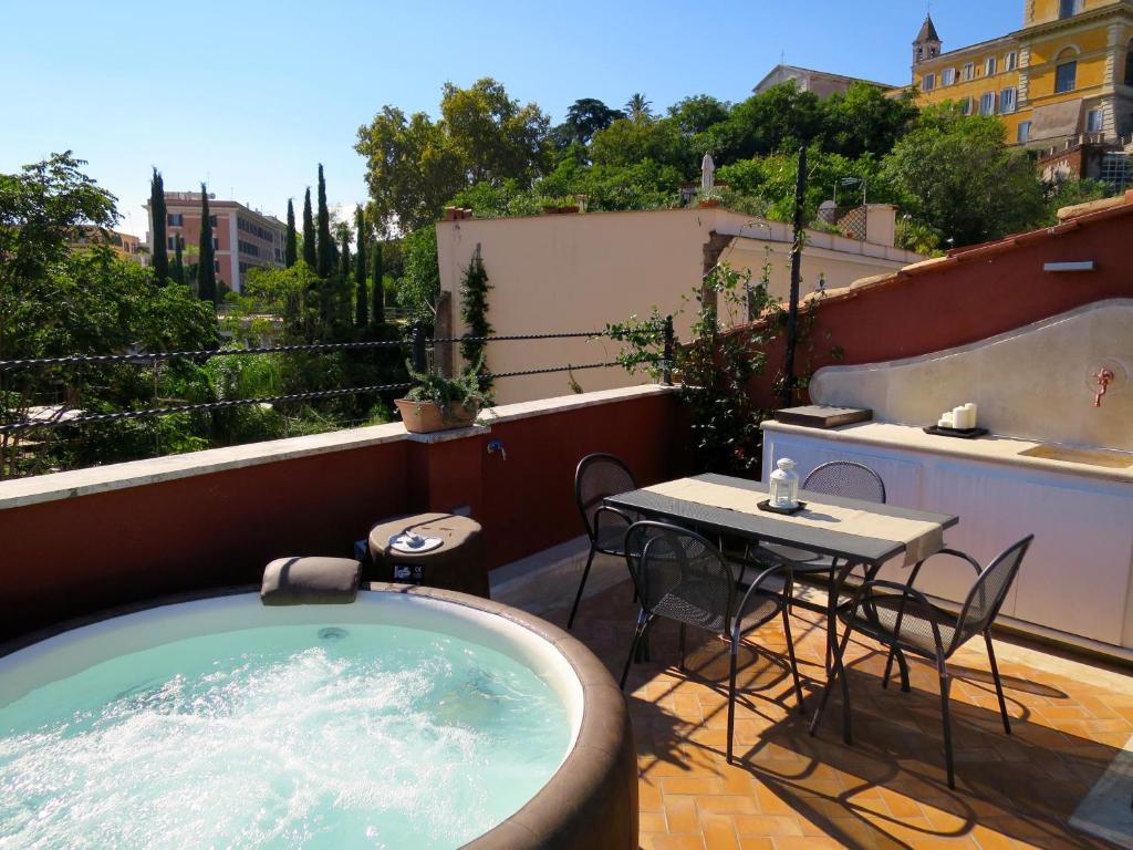 einen Whirlpool auf einem Balkon mit einem Tisch und Stühlen in der Unterkunft Residenza del Cedro in Rom