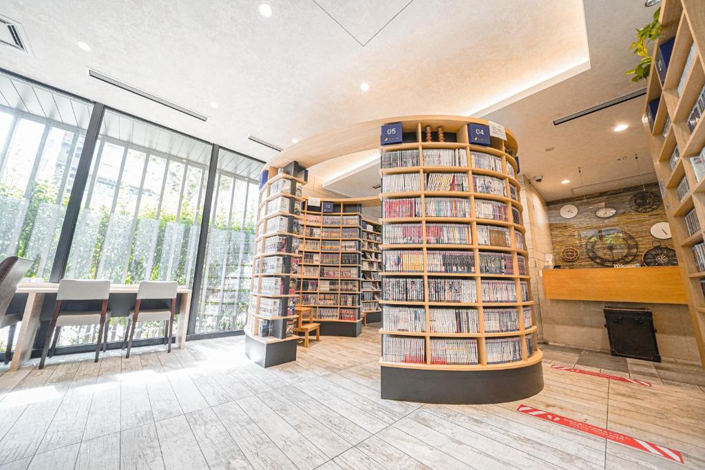 uma biblioteca com uma grande quantidade de livros nas prateleiras em QuintessaHotel TokyoHaneda Comic&Books em Tóquio