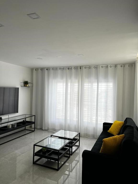 a living room with a couch and a tv at מישל נופש ,צופית תחתית 6003 in Eilat