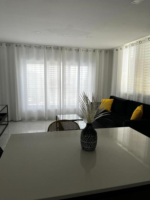 a living room with a vase on a table at מישל נופש ,צופית תחתית 6003 in Eilat