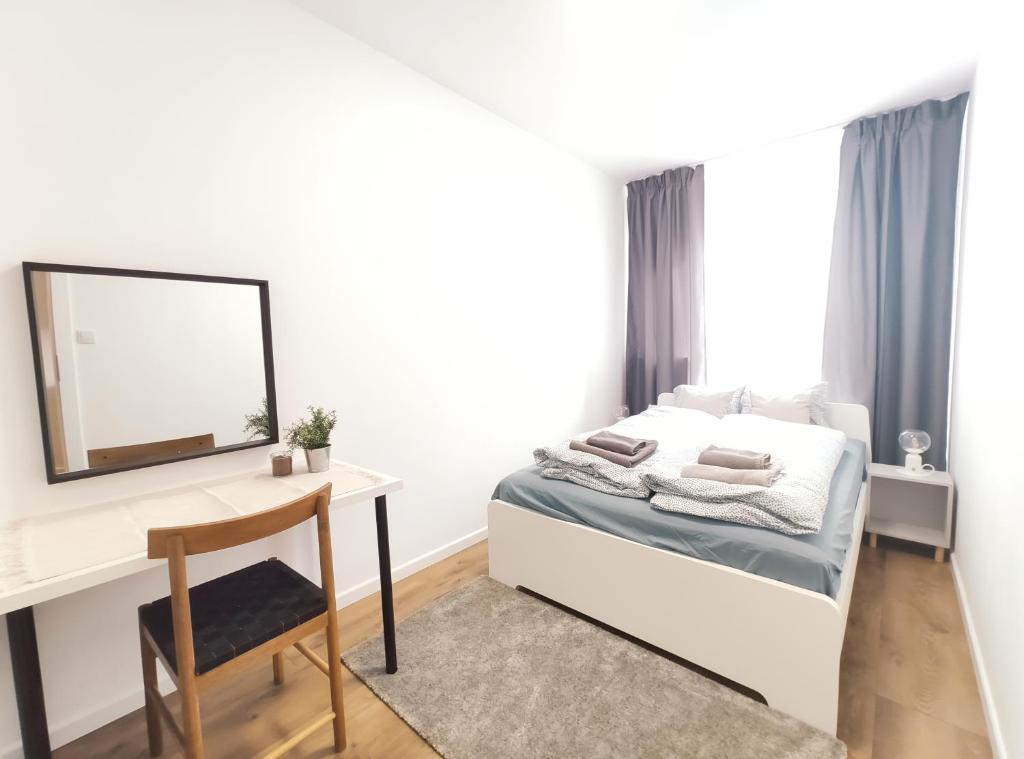 a bedroom with a bed and a desk and a mirror at Mogilska 120D by Homeprime in Kraków