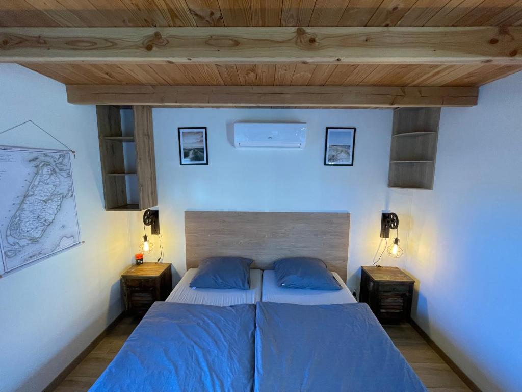 a bedroom with a blue bed with two night stands at Bed & Bike Gasthuus Texel in Den Burg