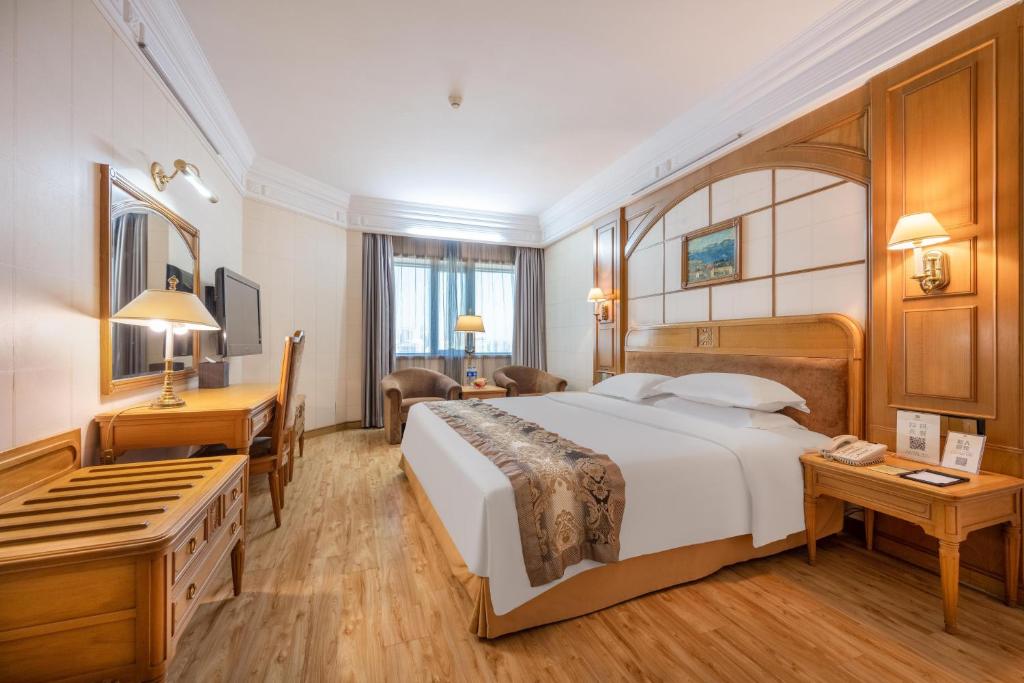 Habitación de hotel con cama grande y escritorio. en Hotel Silverland, en Dongguan