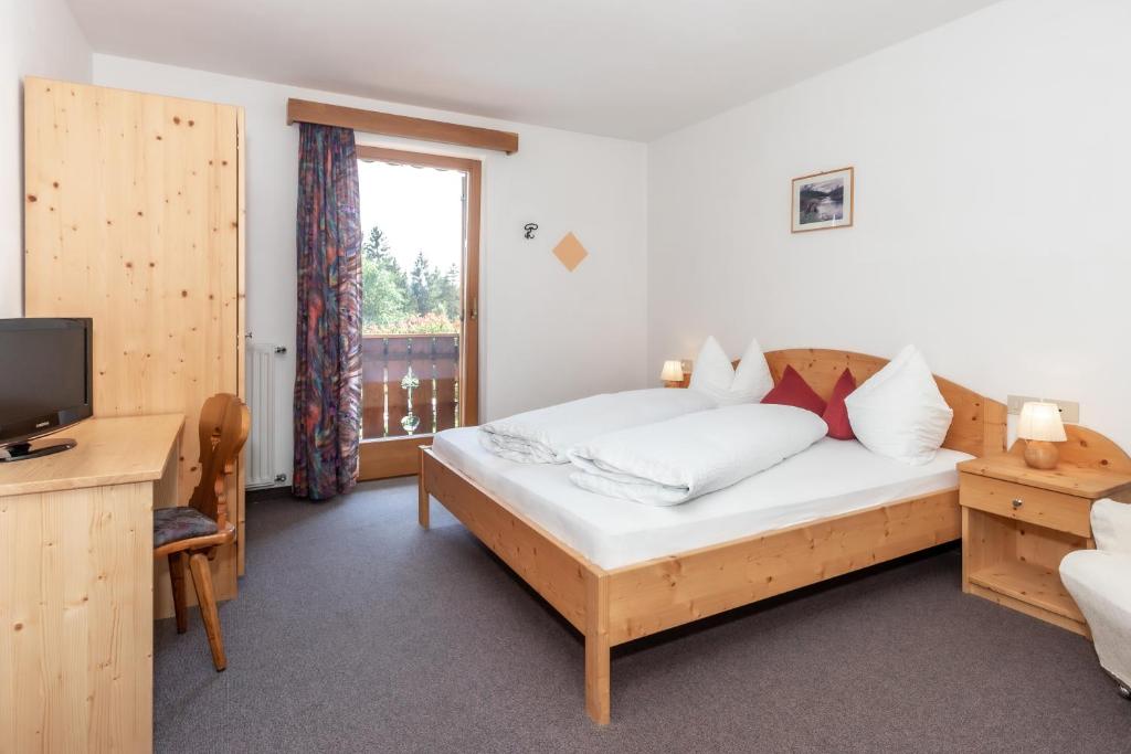 1 dormitorio con 1 cama, TV y ventana en Hotel Langeshof en Anterivo
